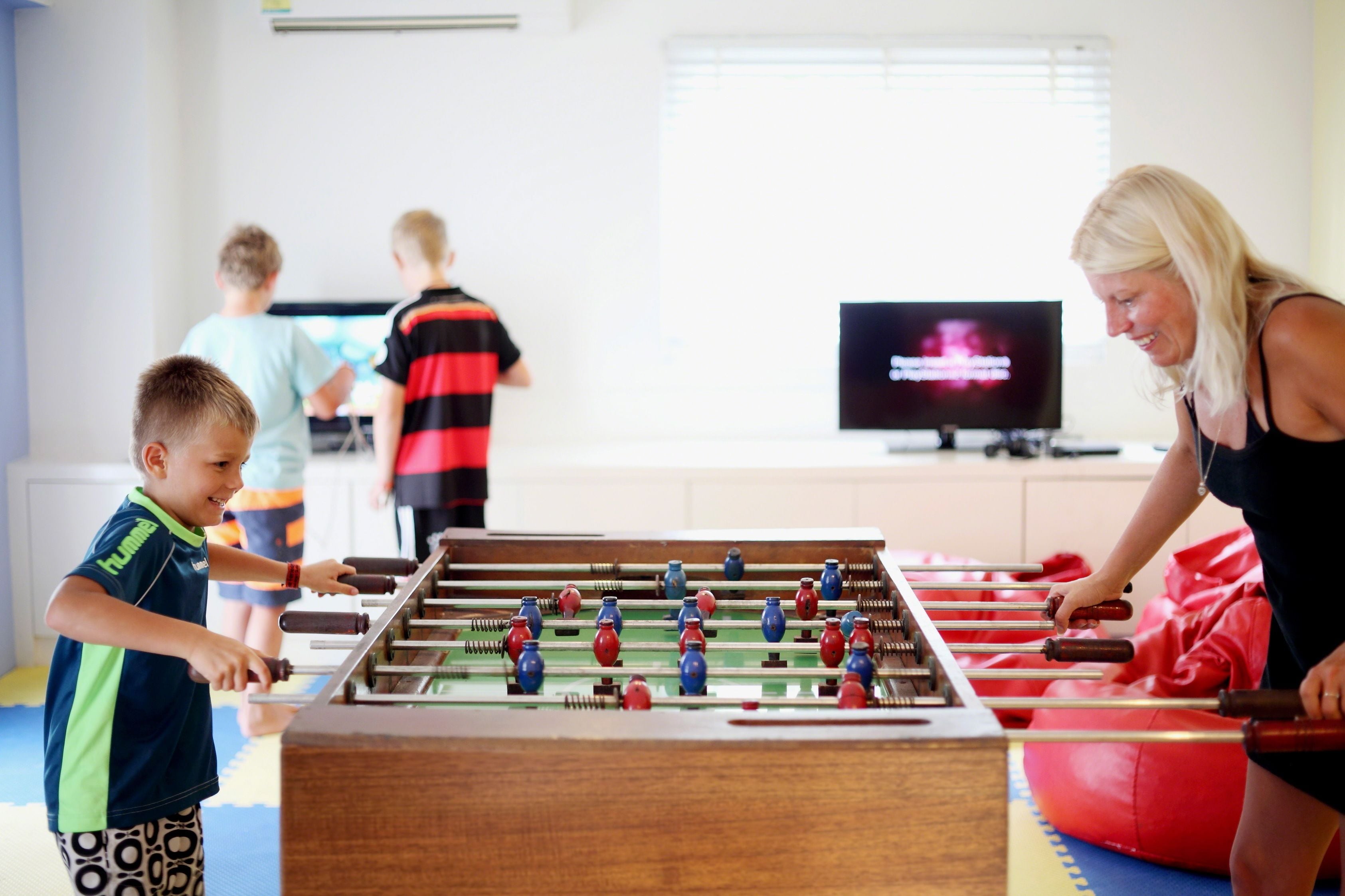 Ein Kicker-Tisch in einem Raum, im Hintergrund ein Fernseher.
