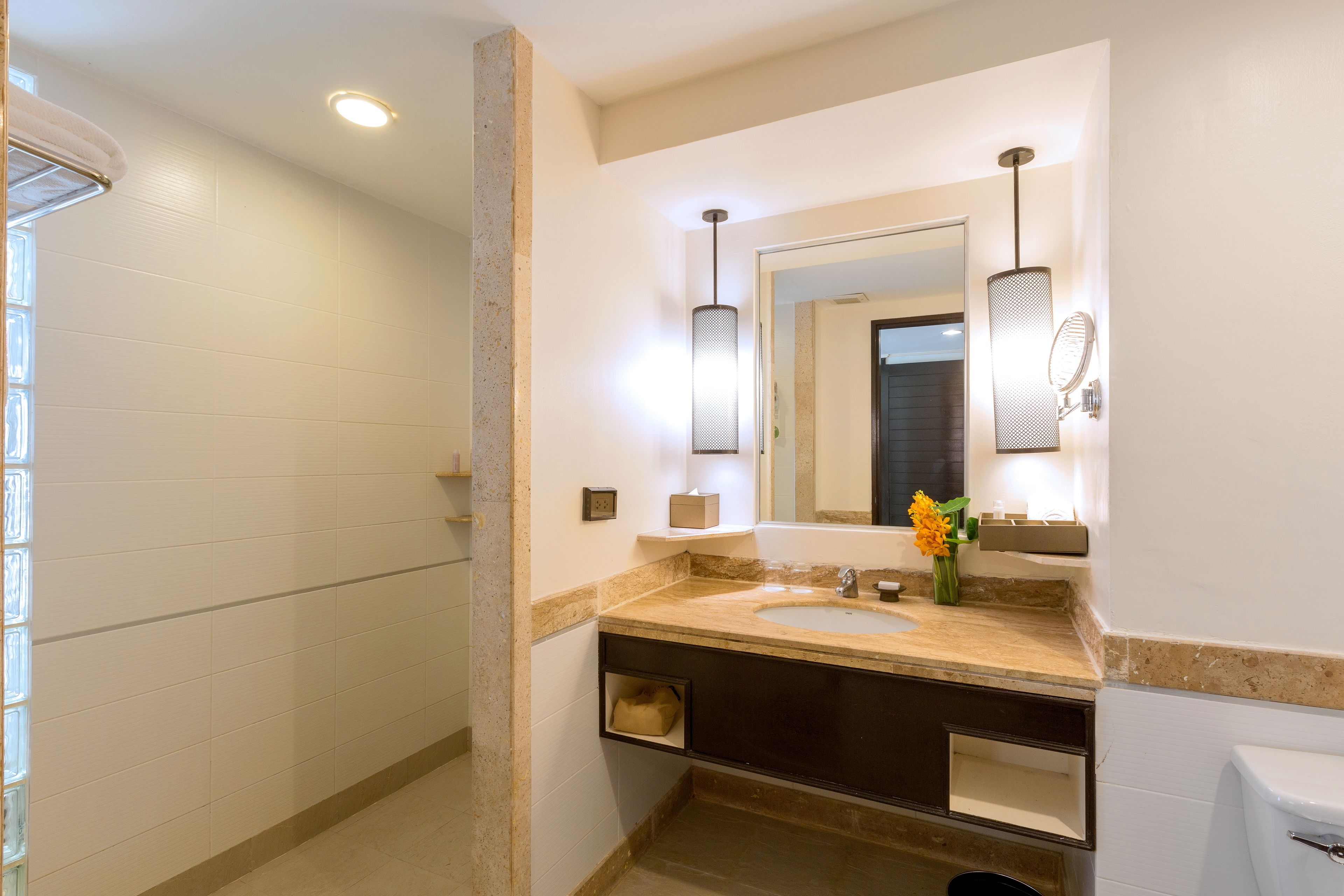 Un baño moderno con un lavabo grande, un espejo y un perchero para toallas.