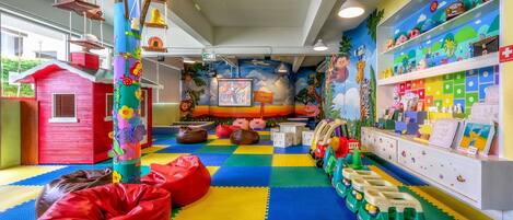 A children's play area with colorful mats, bean bags, and toys.