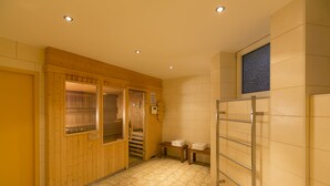 A room with wooden walls, a tiled floor, a wooden bench, a metal rack, and a window with a starry view. - Wald & Golfhotel Lottental (Bochum)
