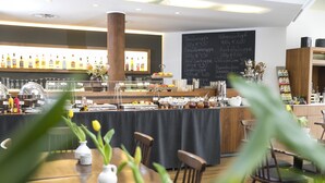 A restaurant with a bar area, a chalkboard menu, and a variety of dishes displayed. - Wald & Golfhotel Lottental (Bochum)