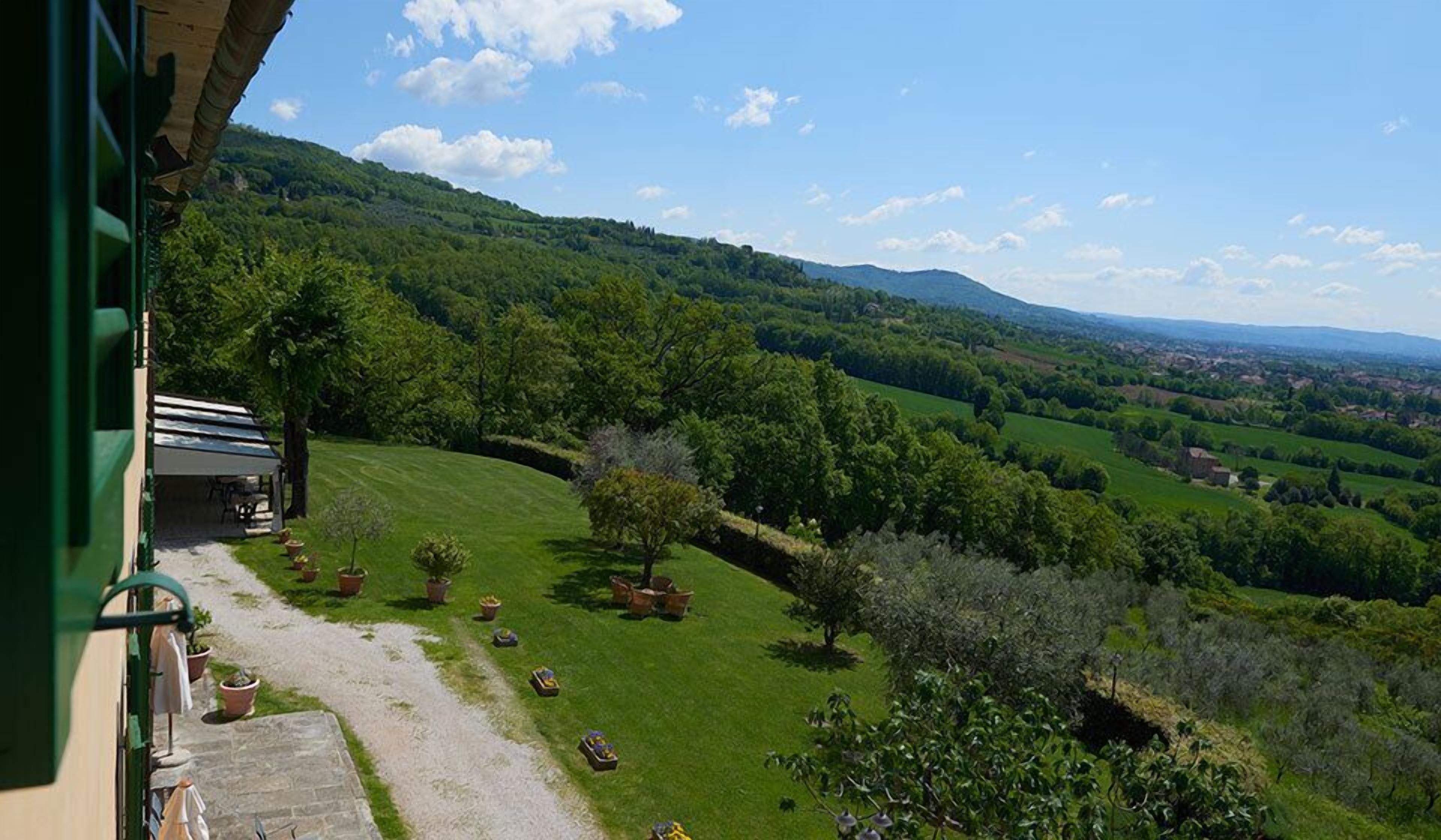 A view of a lush green landscape with rolling hills and a clear sky.
