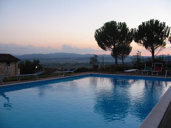 Una piscina al aire libre de temporada, sombrillas