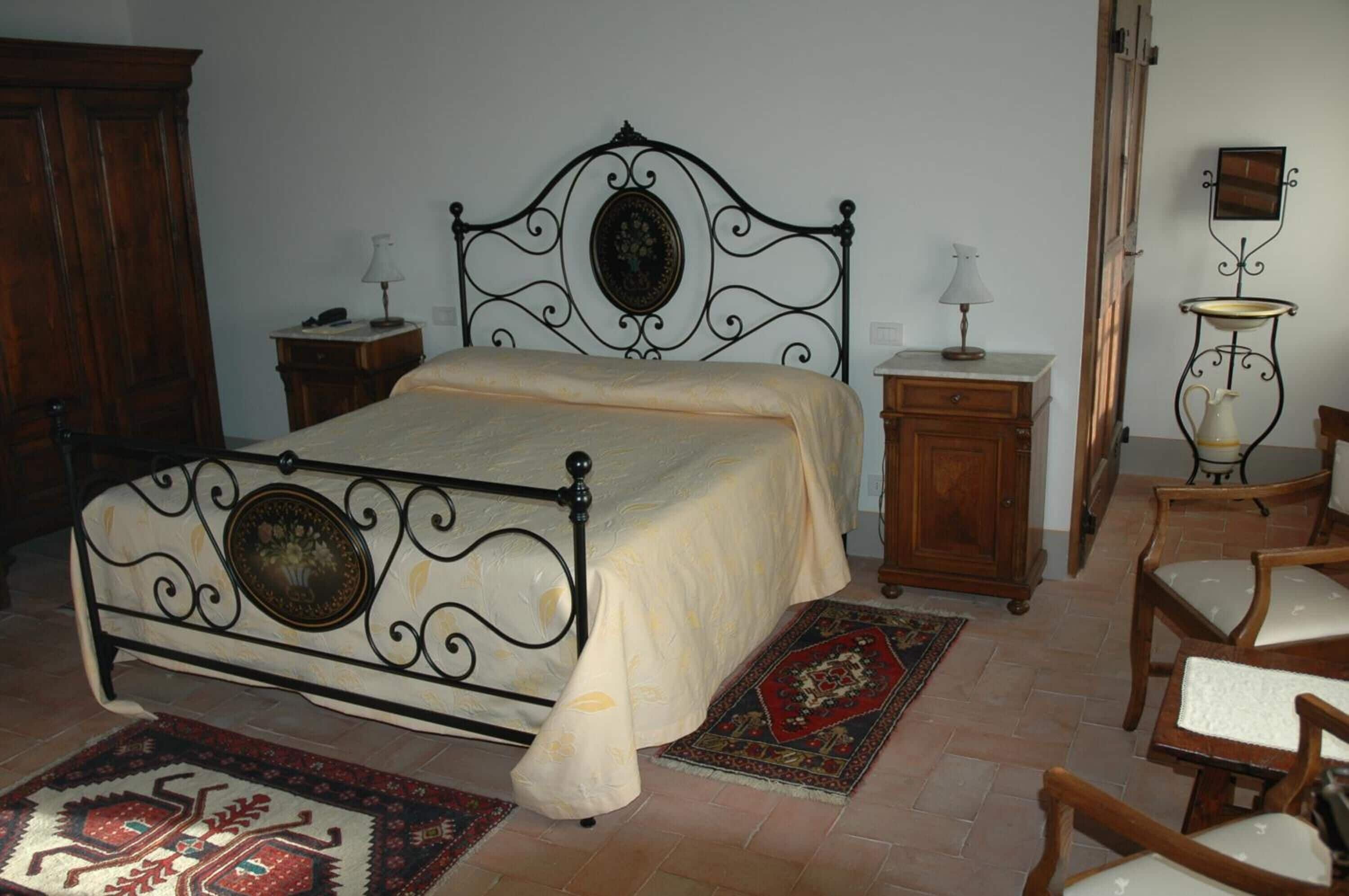 Un dormitorio con cama con dosel, muebles de madera y una alfombra tradicional.