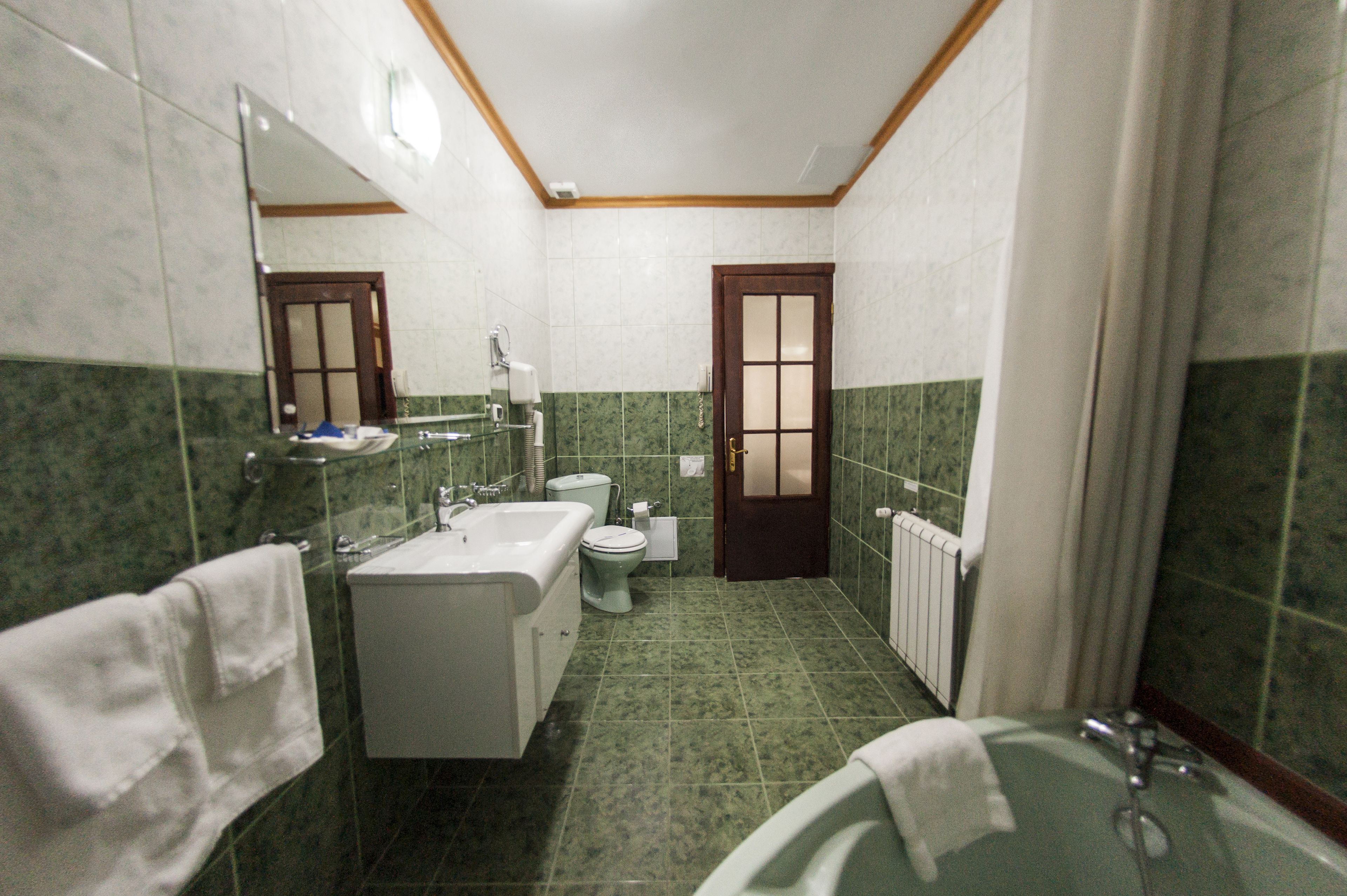 Un baño con bañera, lavabo, inodoro y espejo.