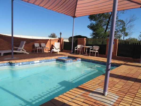 Una piscina al aire libre, tumbonas