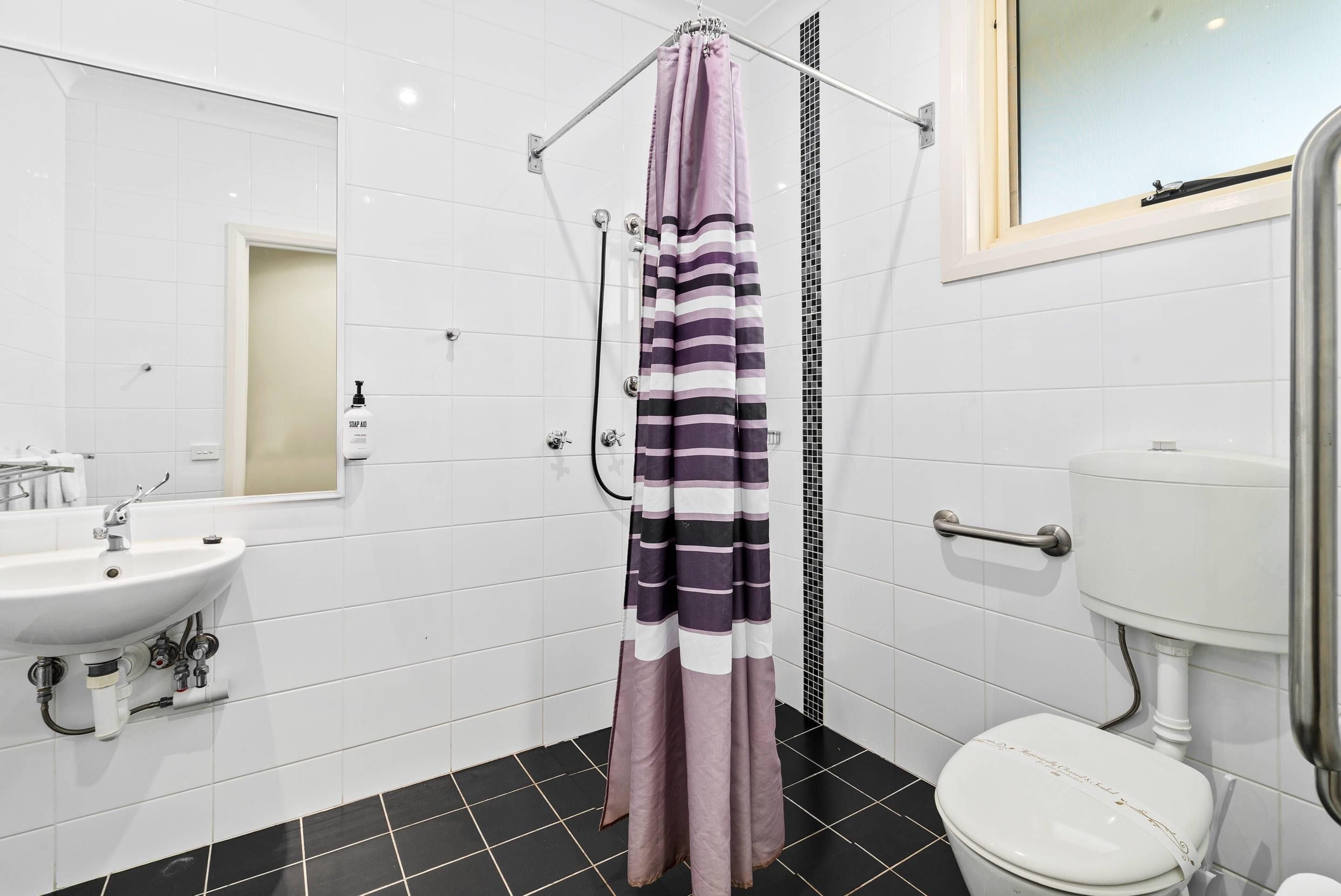 A bathroom with a white sink, a toilet, and a shower curtain.