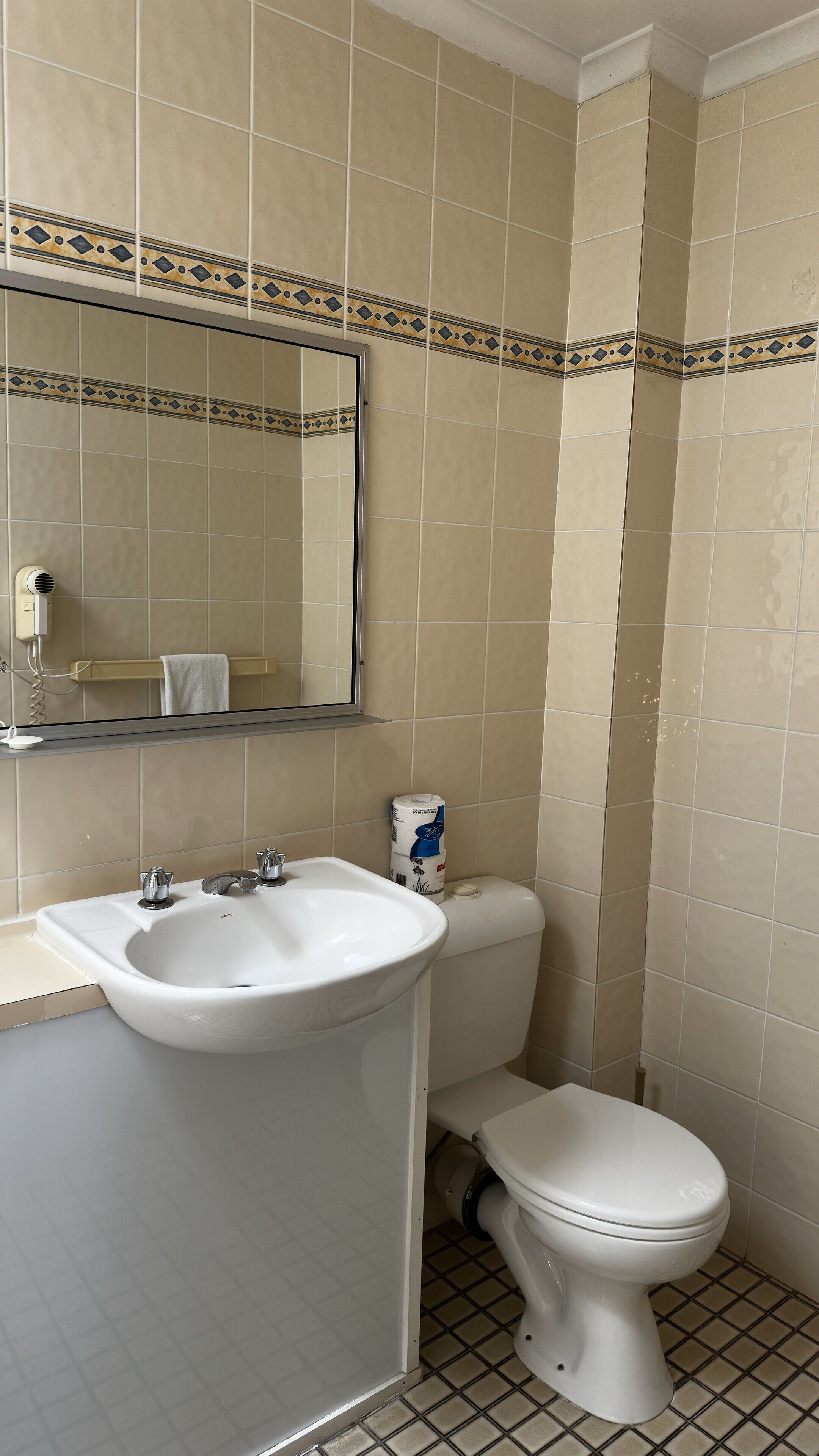 A bathroom with a sink, toilet, and a towel rack.