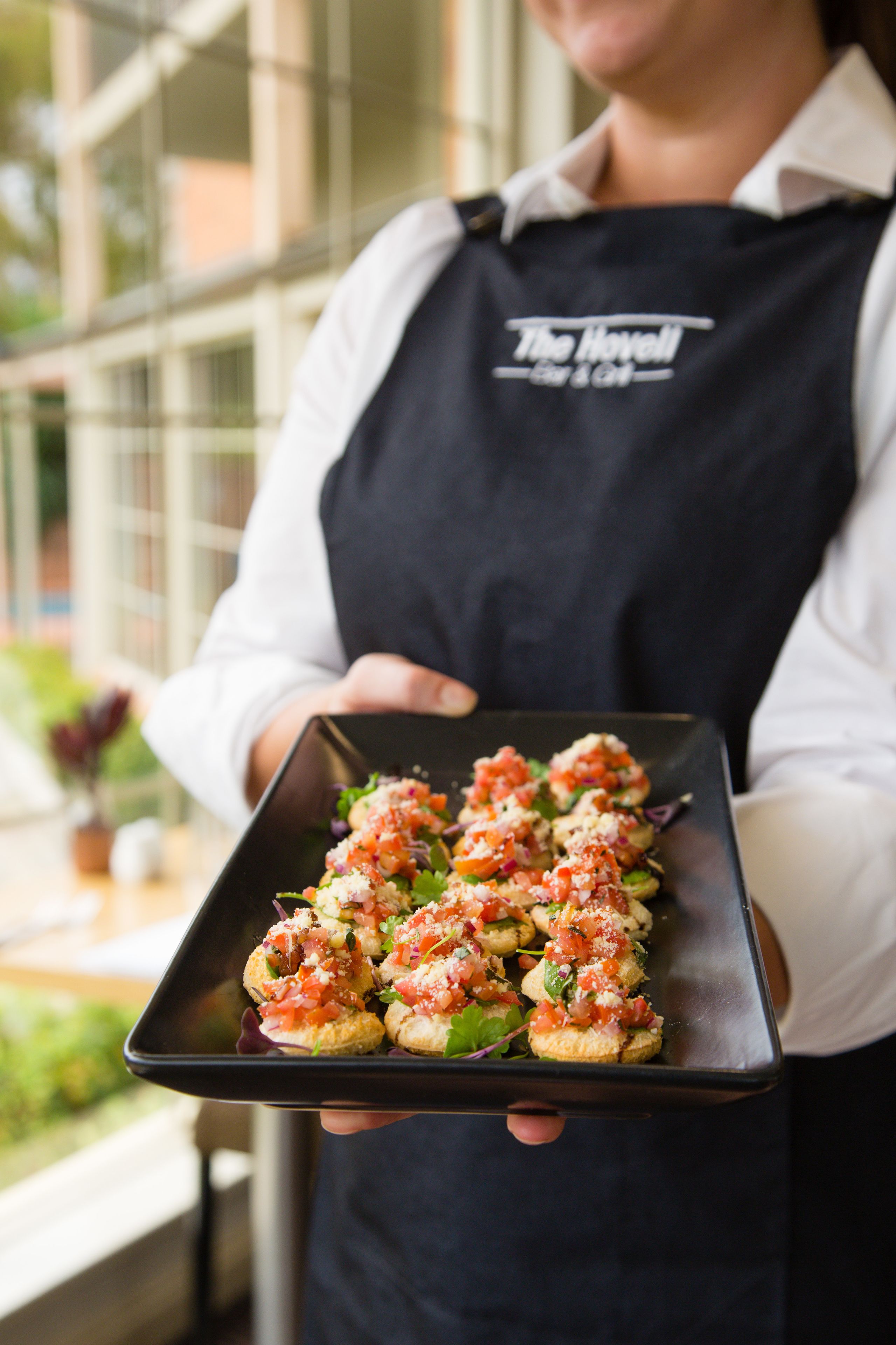 A person holding a tray with food items.