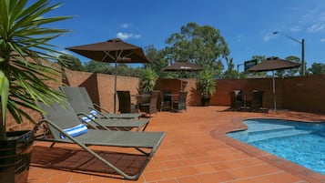 Alberca al aire libre y camastros