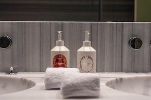 A bathroom with two bottles of soap on sinks and a towel on the counter. - Palazzo Excelsior - The Leading Hotels of the World (Palermo)