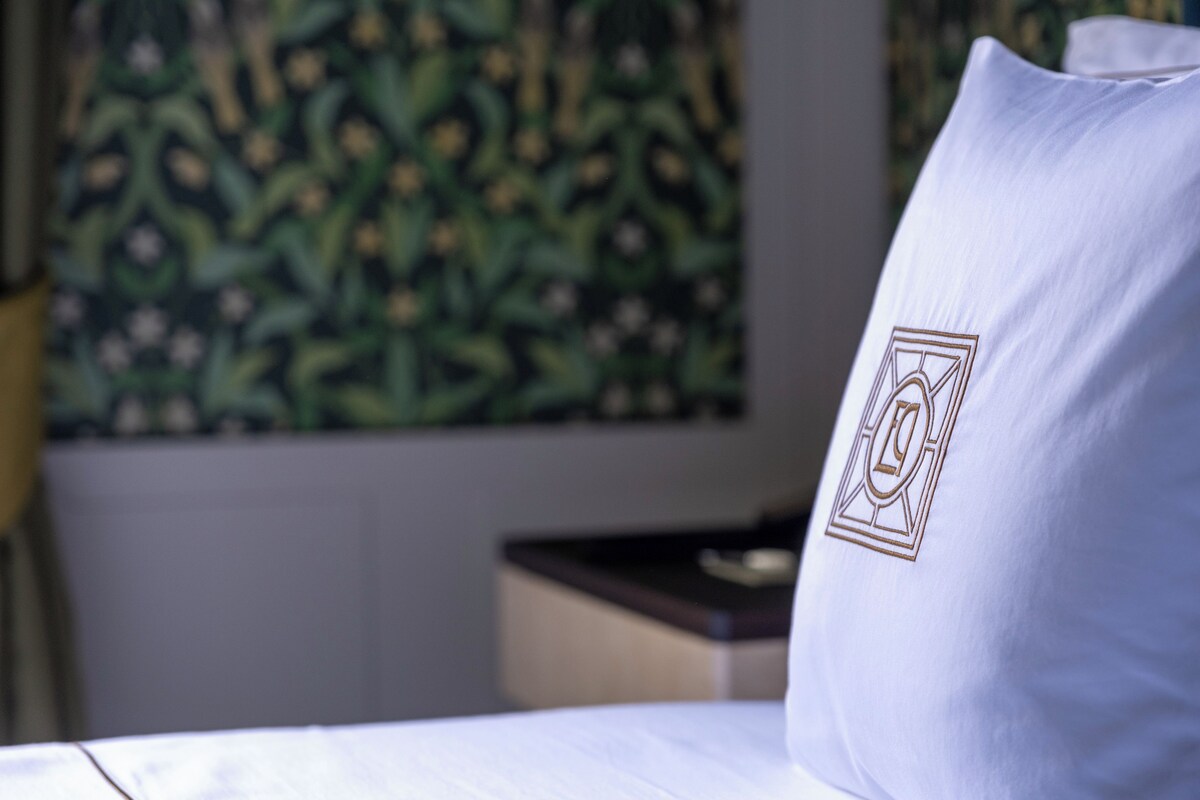 A pillow with a logo on a bed.