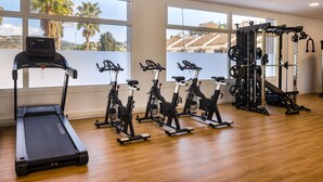 A gym with a treadmill, stationary bikes, and weightlifting equipment. - htop Olympic (Calella)