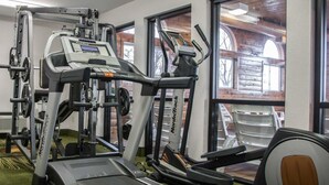 A gym with cardio machines, weightlifting equipment, and a treadmill. - Quality Inn & Suites Loves Park near Rockford (Loves Park)