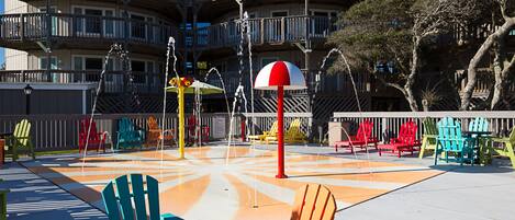 A colorful outdoor seating area with multiple Adirondack chairs and a yellow table.