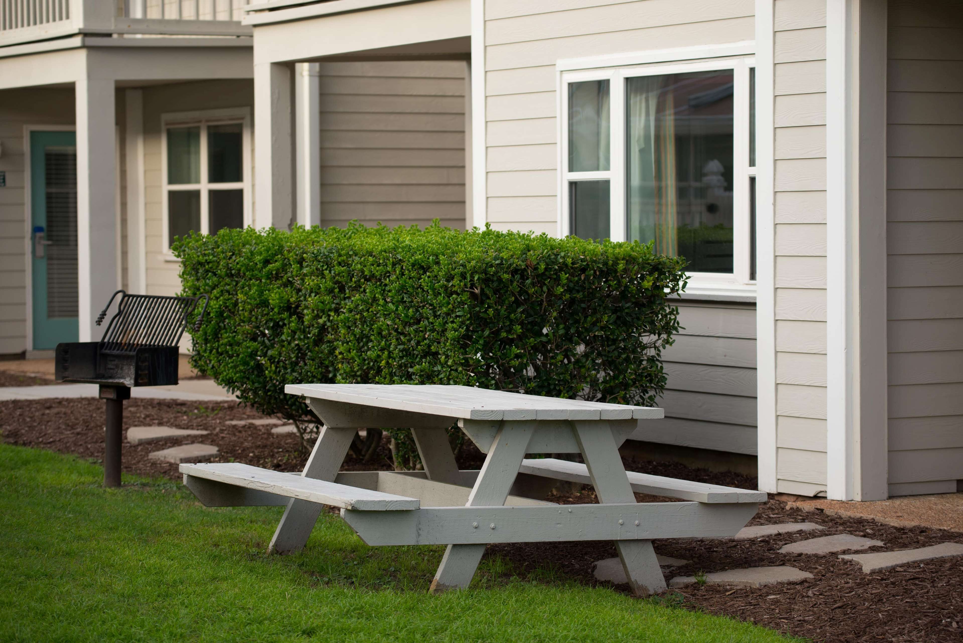 Een picknicktafel voor een gebouw met een raam en een brievenbus.