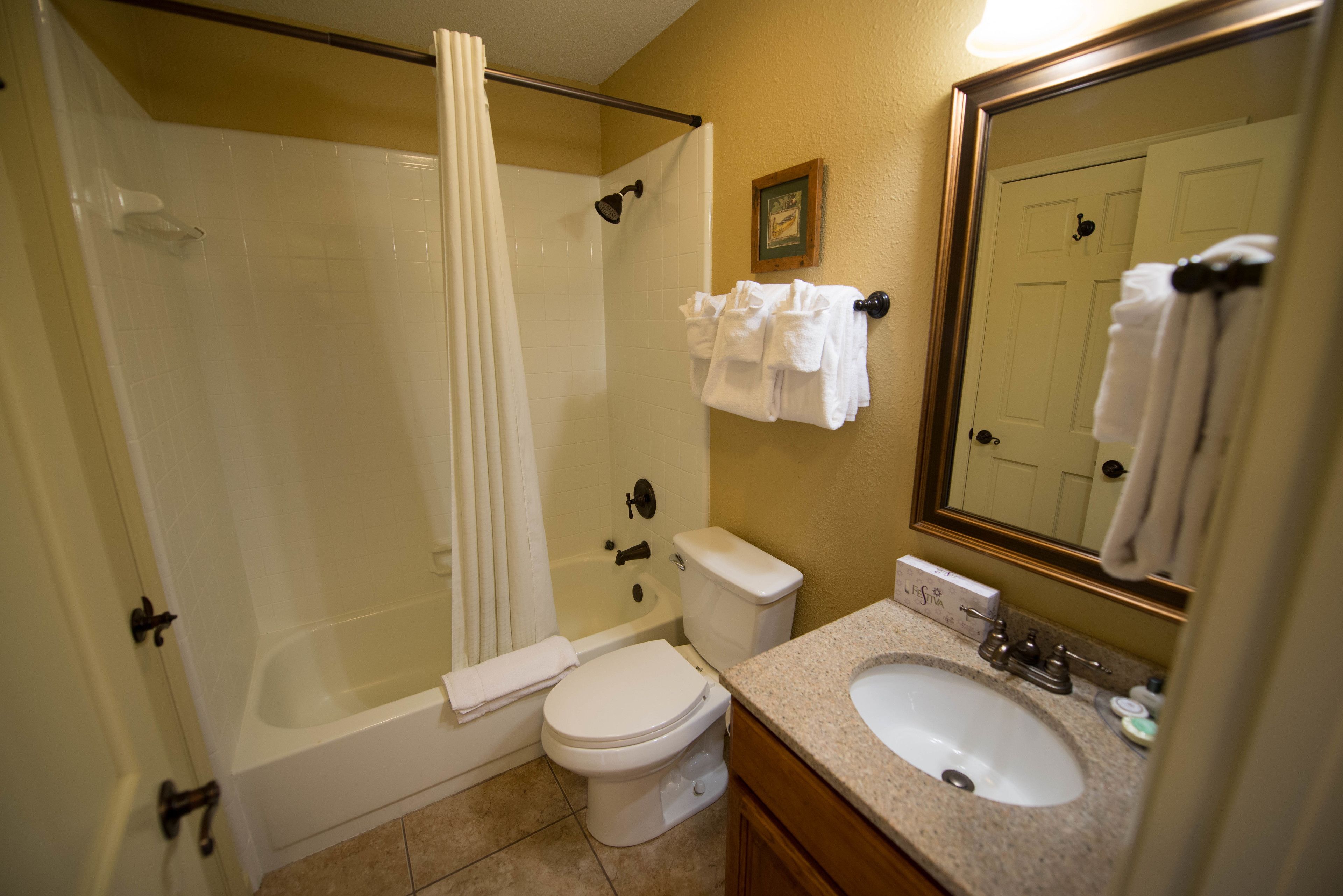 A bathroom with a bathtub, toilet, and sink.