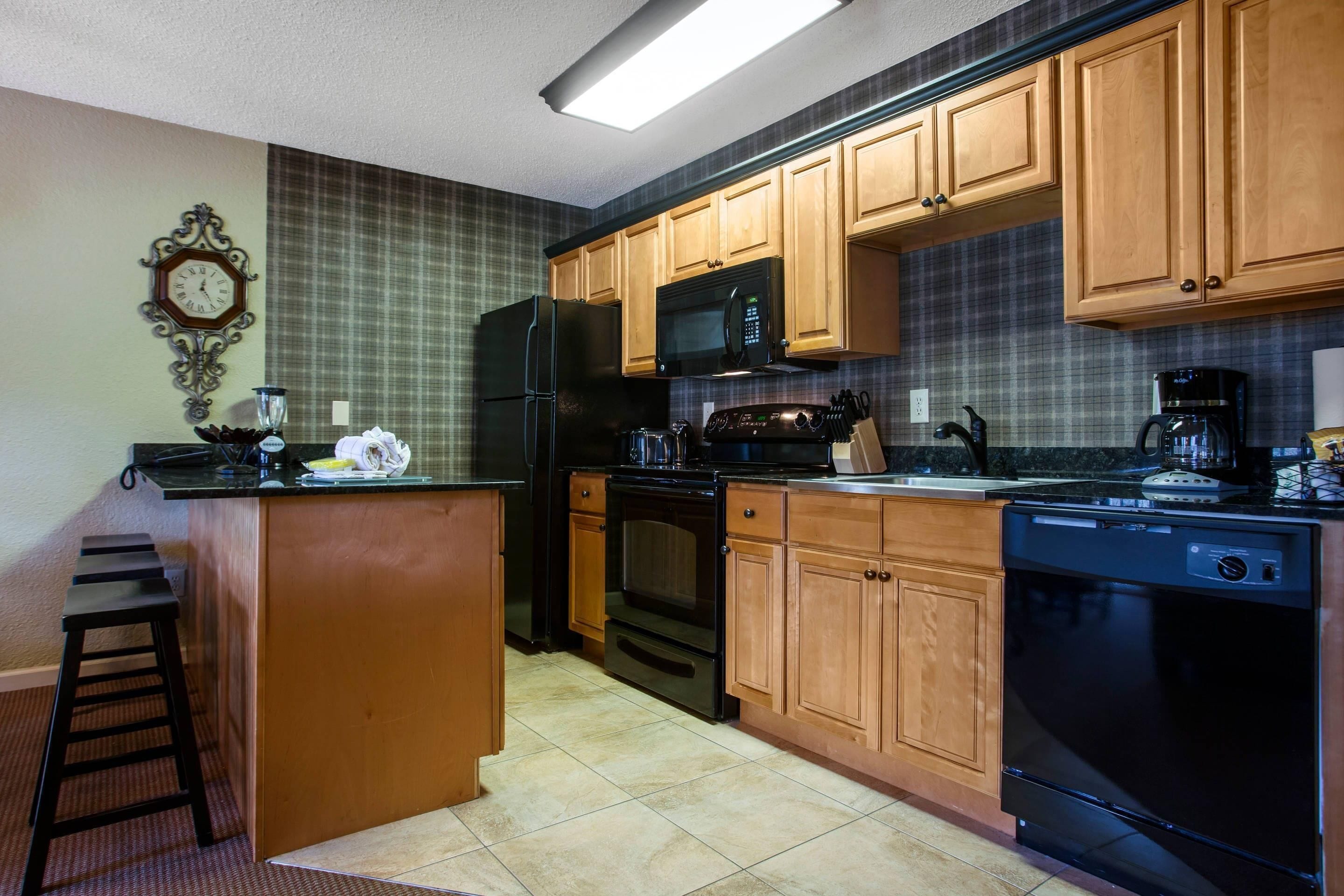 A kitchen with wooden cabinets, a refrigerator, a microwave, an oven, and a dishwasher.