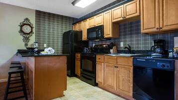 A kitchen with wooden cabinets, a refrigerator, a microwave, an oven, and a dishwasher.