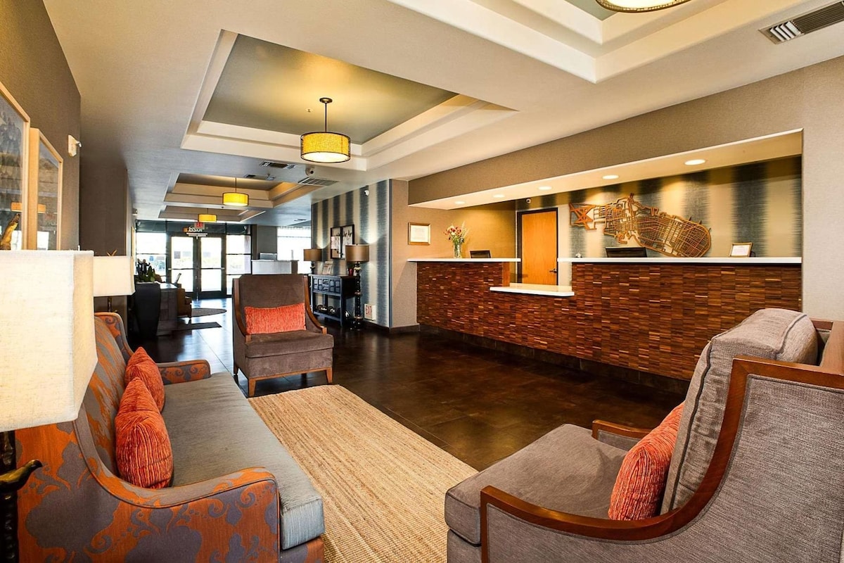 A lobby with a reception desk, seating area, and a large window.