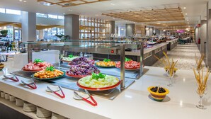 A buffet area with various food options, a glass display case, and a modern interior design.