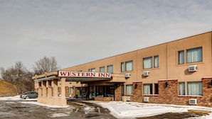 Edificio del Western Inn con letrero, ventanas y unidades de aire acondicionado.