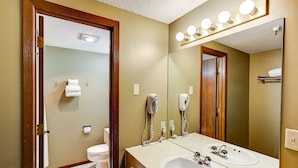 Un baño con dos lavamanos, un espejo y un inodoro.