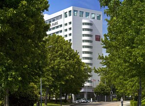 Un moderno edificio de hotel con un letrero 'PARK', varios pisos y un letrero 'HF' que indica hotel.