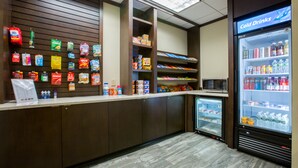 A snack bar with a variety of packaged snacks and a refrigerated section with beverages. - Holiday Inn Manchester Airport by IHG (Manchester)