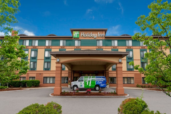 A Holiday Inn Express & Suites building with a van parked in front.
