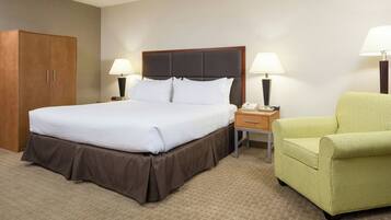 A hotel room with a bed, bedside lamps, a chair, a nightstand, and a wardrobe.