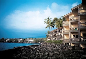 A beachfront hotel with multiple balconies, a pool, and a view of the ocean and mountains. - Sea Village (Kailua-Kona)