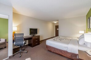 A hotel room with a bed, a desk with a television, a chair, and a lamp. - Sleep Inn & Suites Harrisonburg near University (Harrisonburg)