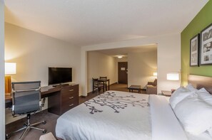 A hotel room with a bed, a desk with a chair, a television, and a dining area. - Sleep Inn & Suites Harrisonburg near University (Harrisonburg)