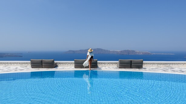 A pool with a clear view of the sea and distant islands. - Xenones Filotera (Santorini)