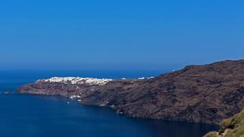 A coastal landscape with rocky terrain and a clear blue sky.