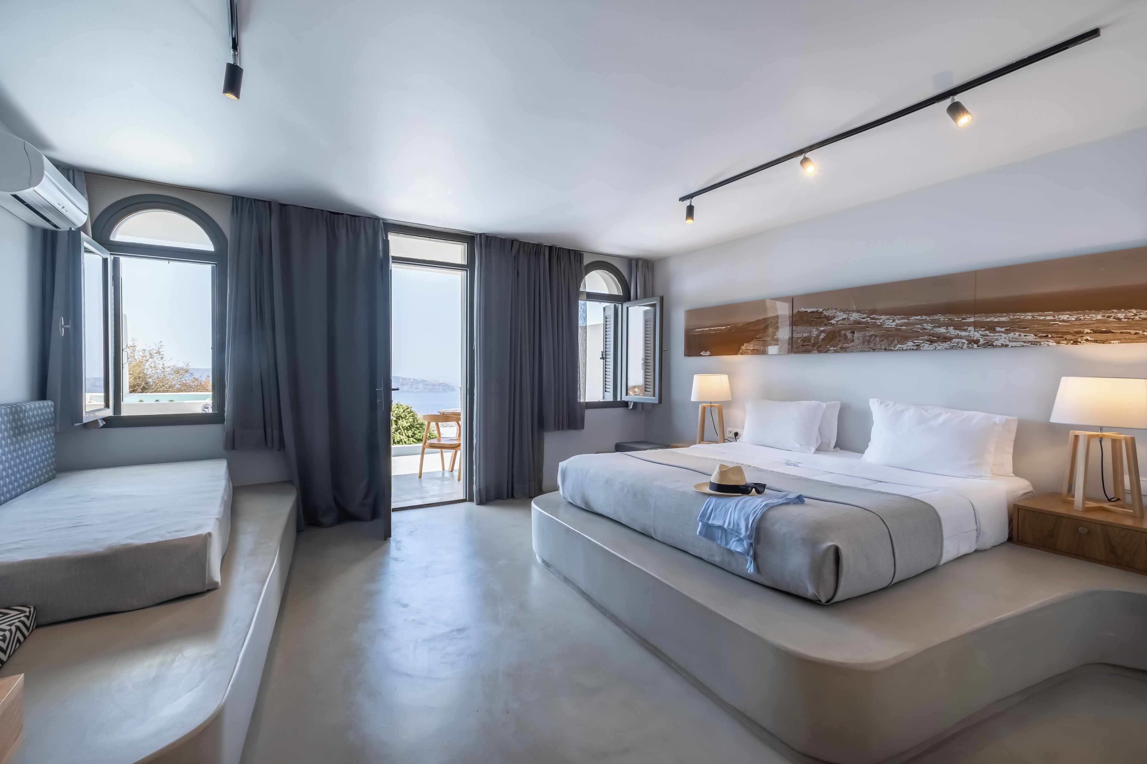 A modern hotel room with a large bed, a seating area, and a view of the outdoors.