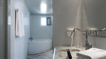 A modern bathroom with a bathtub, a shower with a rain showerhead, and a marble countertop.