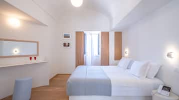 A modern bedroom with a large bed, bedside table, and a mirror.