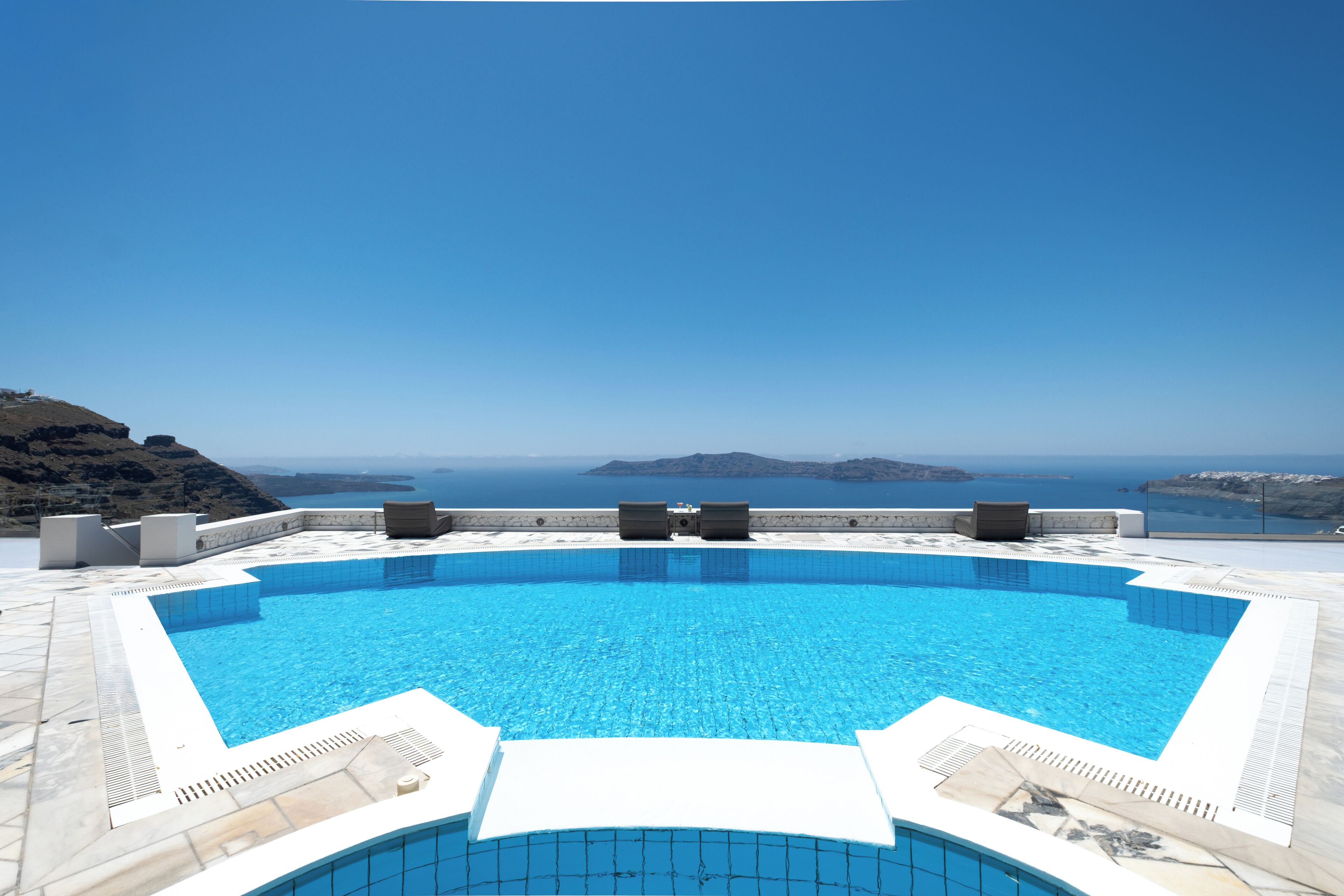 Una piscina con vista despejada al mar y a islas distantes.