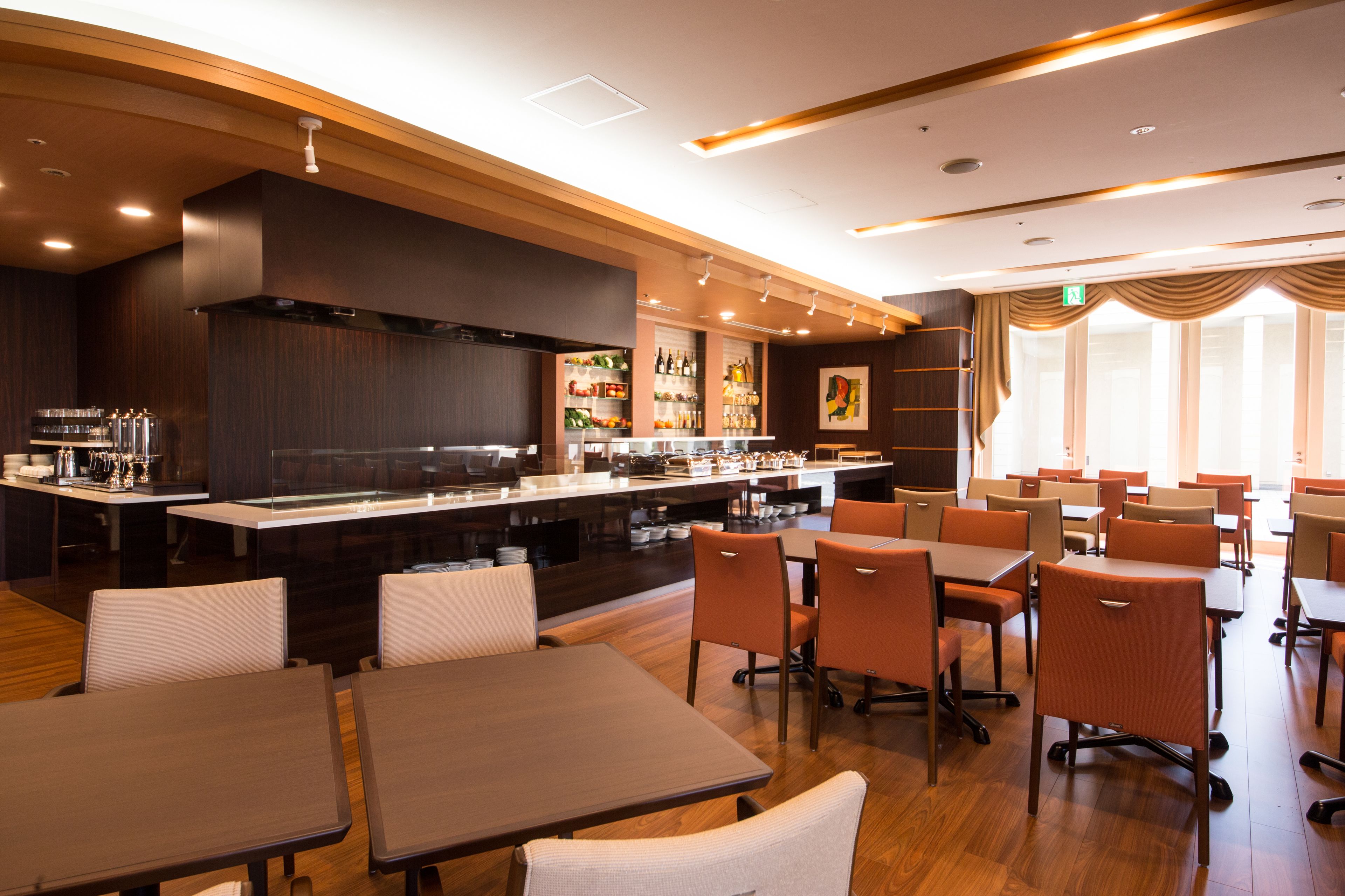 A modern restaurant with a bar area, multiple dining tables, and chairs.
