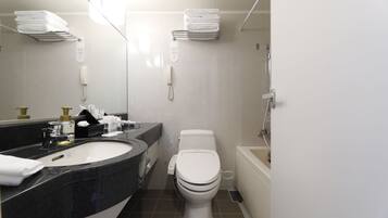 A modern bathroom with a sink, toilet, and bathtub.