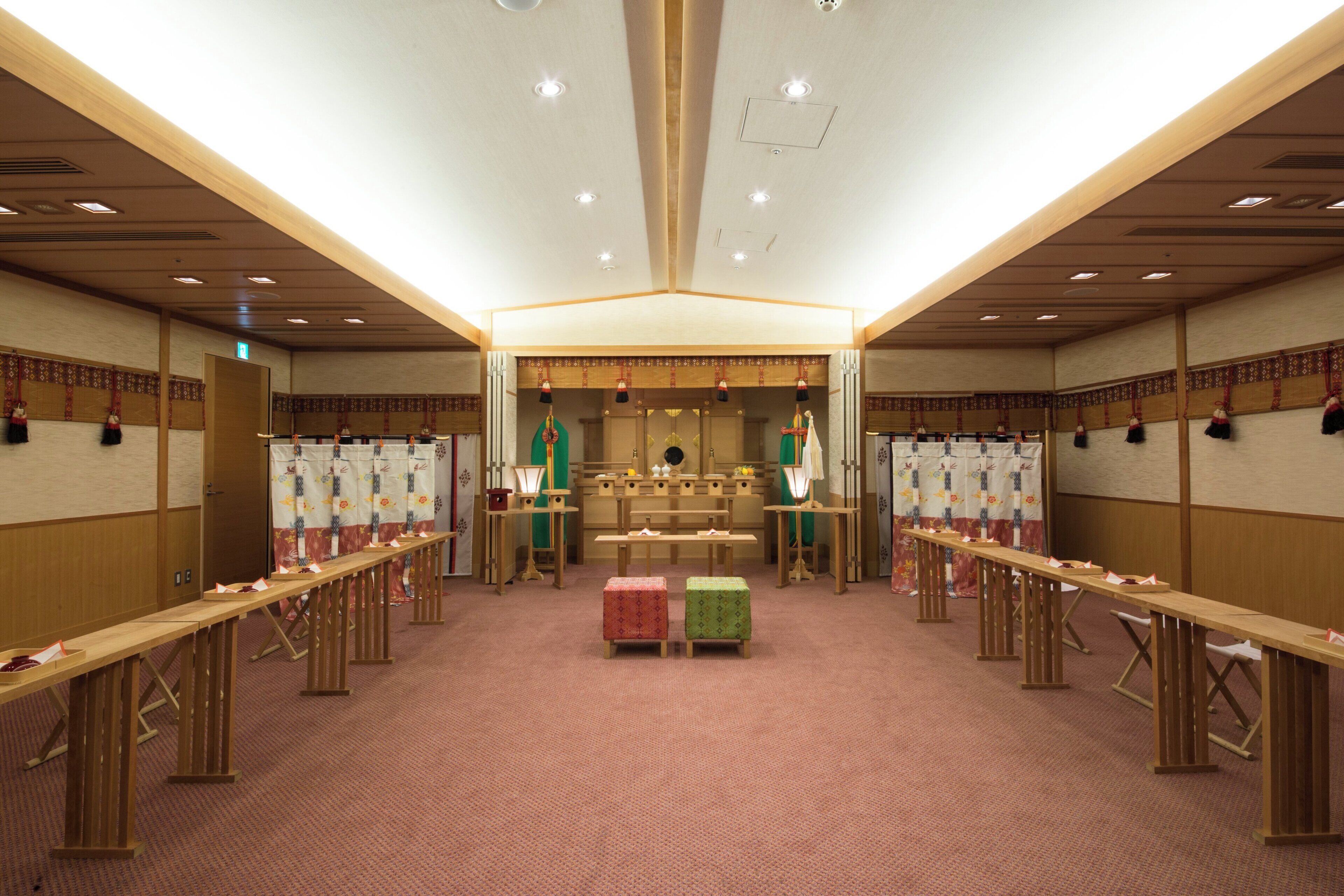 A conference room with long tables, chairs, and a podium at the front.