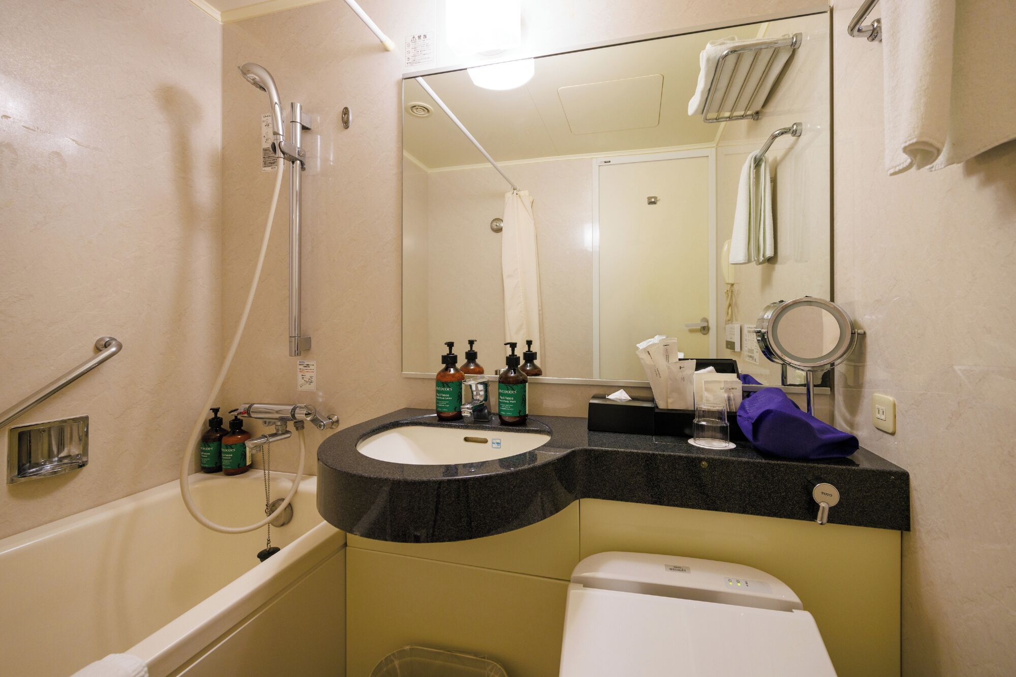 A bathroom with a bathtub, a sink, a toilet, a shower, and a mirror.