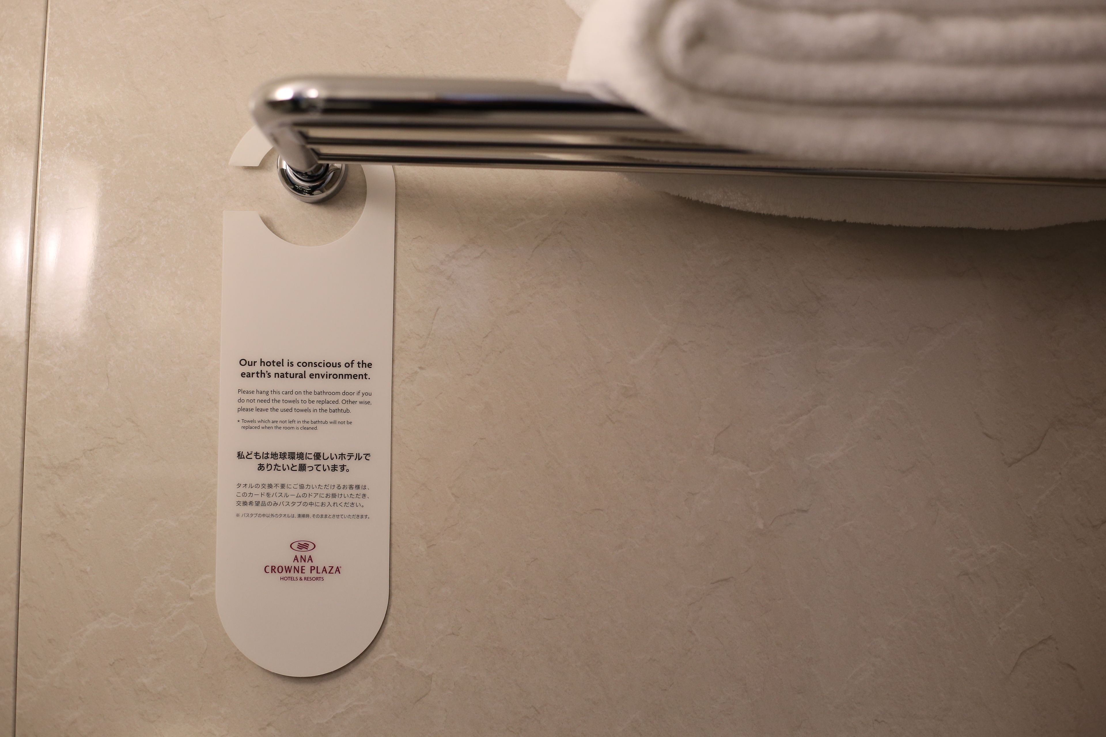 Un baño con un perchero y un cartel con información del hotel.