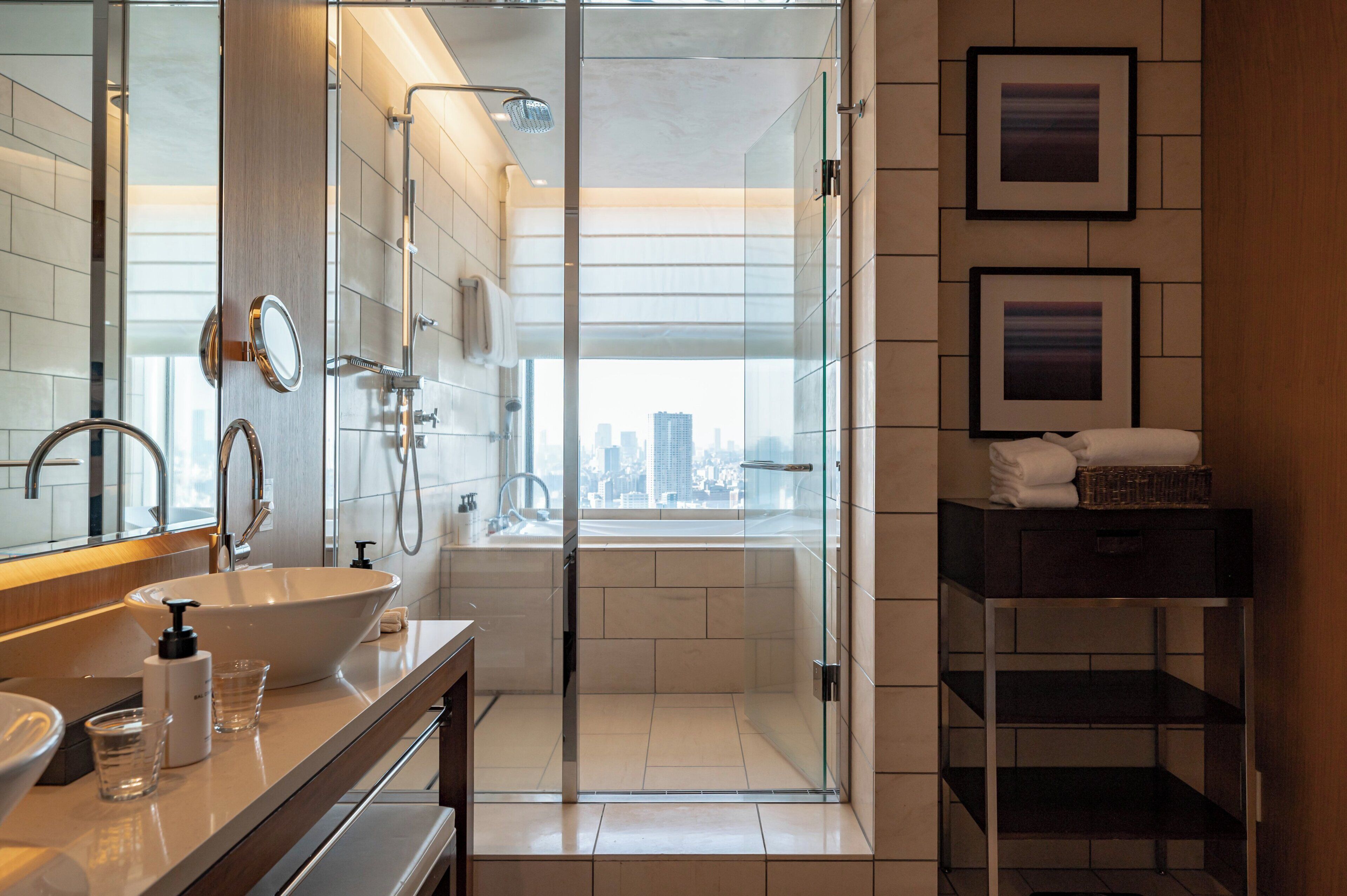 A modern bathroom with a large sink, mirror, and glass shower enclosure.