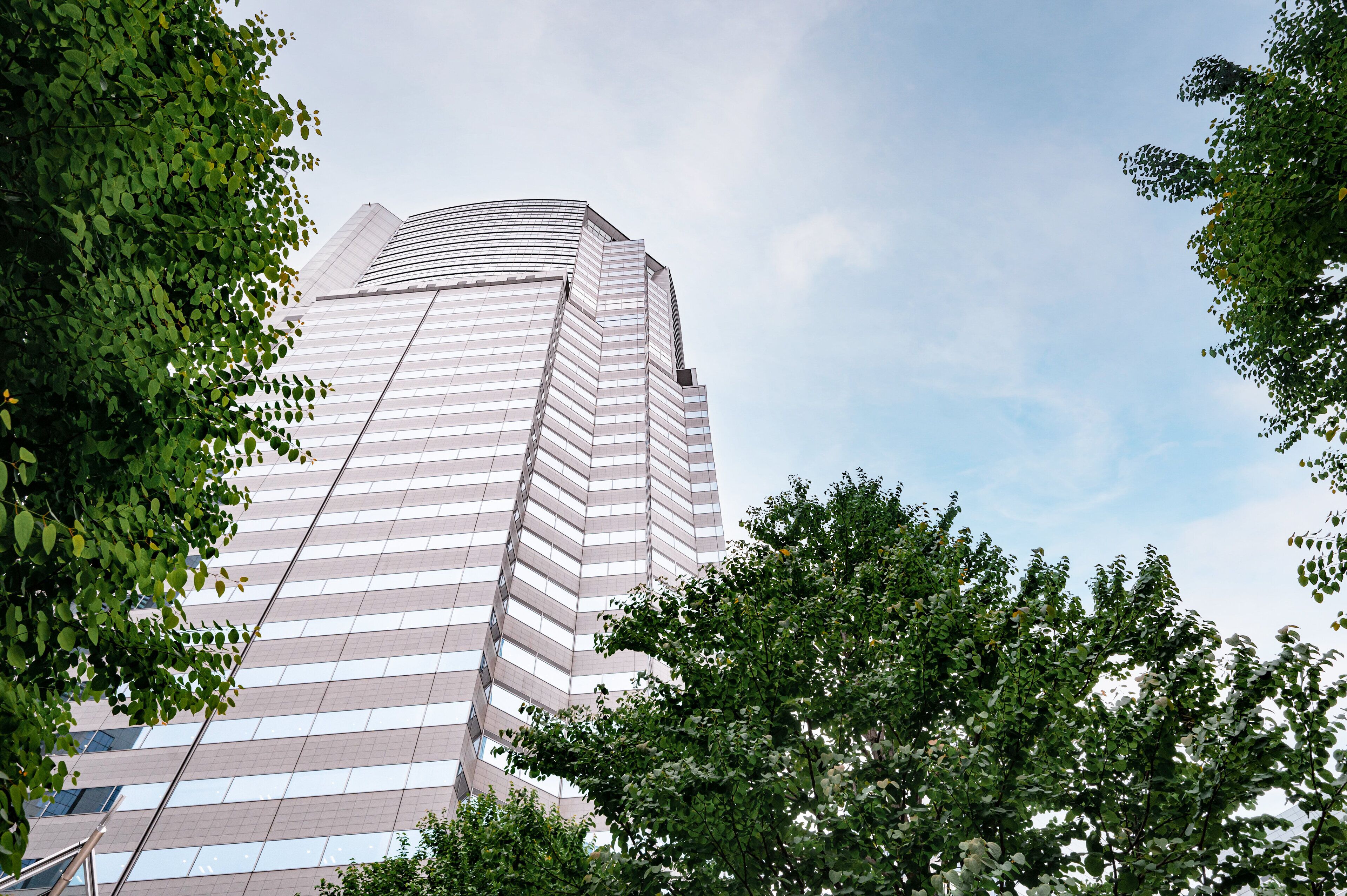 A modern high-rise building with a curved facade and large windows.