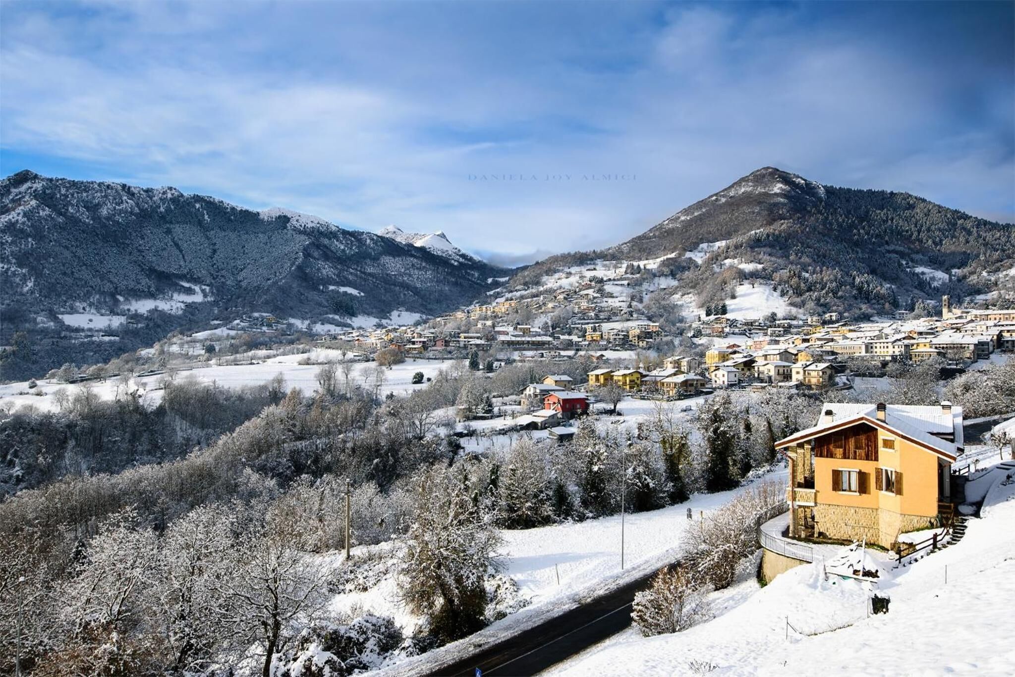 A snow-covered mountain village with traditional houses and a clear sky.