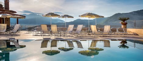 Una piscina al aire libre, tumbonas