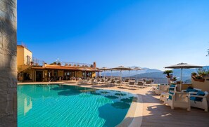 A poolside area with lounge chairs, umbrellas, and a view of mountains. - La Vue D'Or (Sorrento)